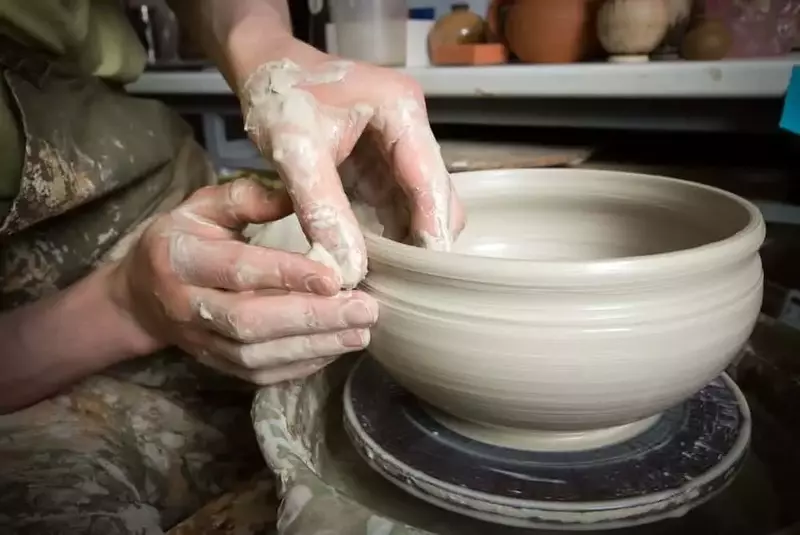 hands of a potter making a clay bowl